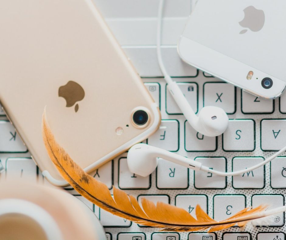 gold iPhone 7 beside white Apple EarPods and silver iPhone 5s